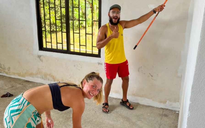 two gap year students paint during a service project with outward bound